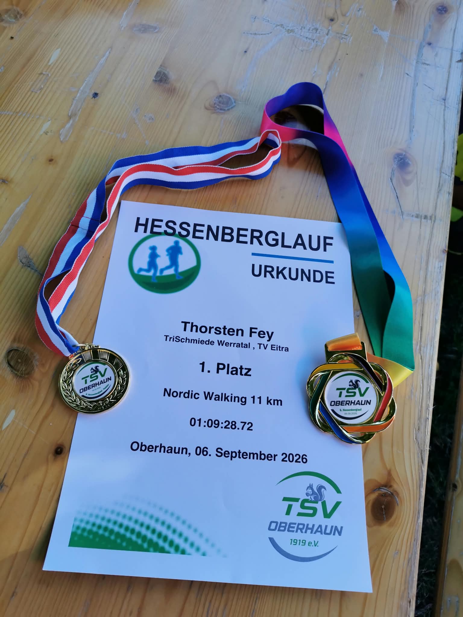 Urkunde und Medaillen von Thorsten Fey – 1. Platz Nordic Walking beim Hessenberglauf in Oberhaun