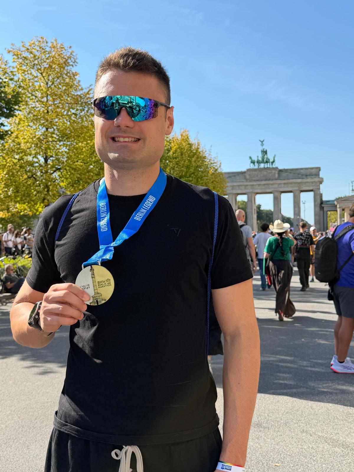 Felix Bahn mit Finisher-Medaille vor dem Brandenburger Tor beim Berlin-Marathon